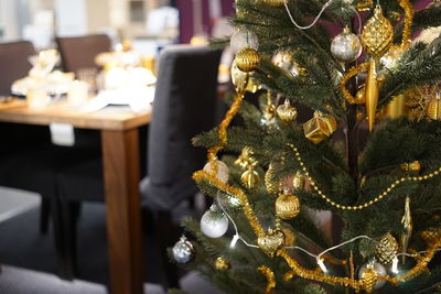 Decorated christmas tree by dinner table at home