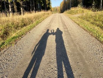 Shadow of man on road in city