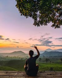 Rear view of woman looking at mountain against sky