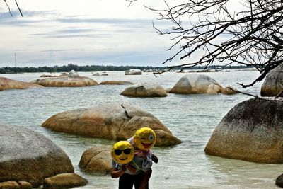 Rear view of man at beach against sky