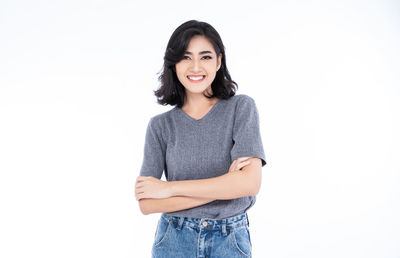 Portrait of a smiling young woman against white background