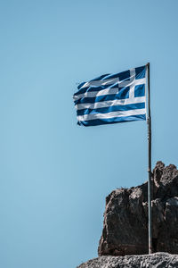 Low angle view of flag against blue sky