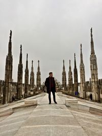 Man standing milan cathedral roof in city against sky