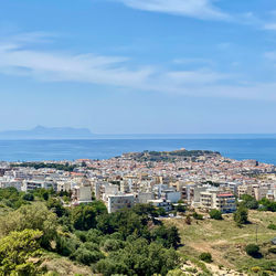 High angle view of townscape by sea against sky