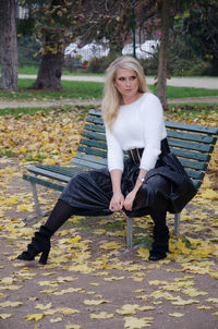 Portrait of smiling young woman sitting on bench