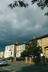 Buildings against cloudy sky