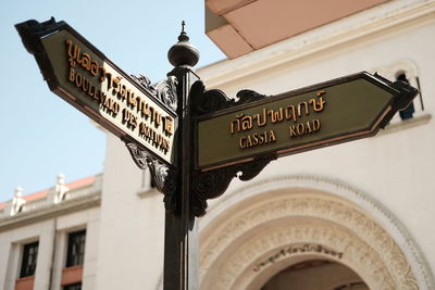 Low angle view of information sign against building