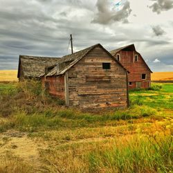 Abandoned house on field against sky