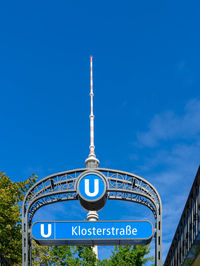 Low angle view of information sign against blue sky