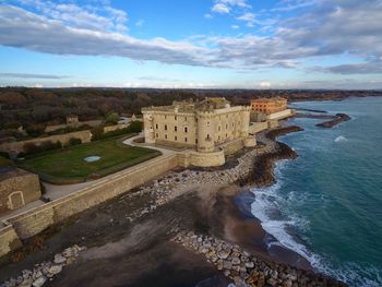 High angle view of castle by sea against cloudy sky