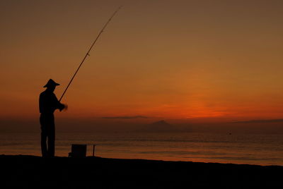 Silhouette man standing at sunset