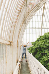 Full length of woman jumping in greenhouse 