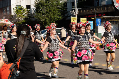 Group of people walking on road along buildings