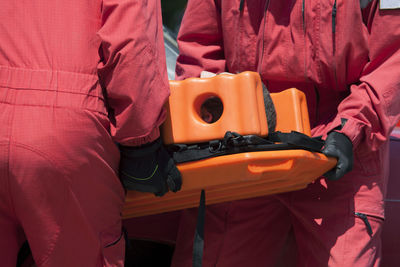 Midsection of paramedics holding patient on stretcher