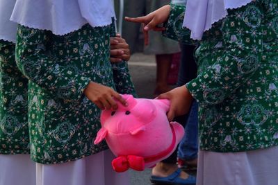 Midsection of girls holding soft toy