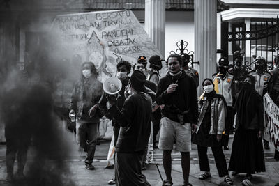 Rear view of people walking on street in city