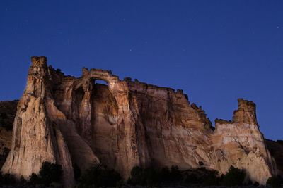 Low angle view of rock formation against clear blue sky