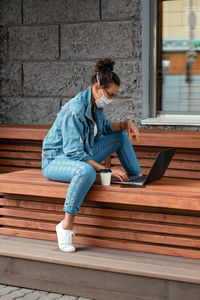 Full length of woman using laptop outdoors