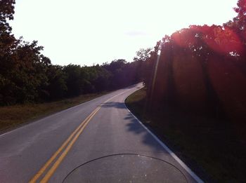 Empty road along trees