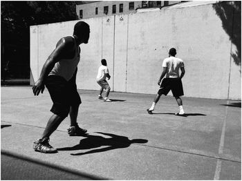 REAR VIEW OF PEOPLE PLAYING WITH BALL ON THE FLOOR