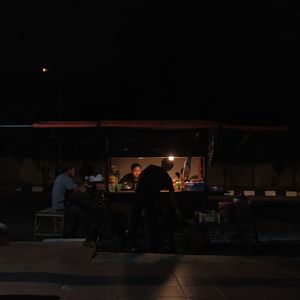 Group of people in front of illuminated building at night