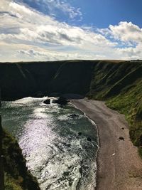 Scenic view of road by mountain against sky