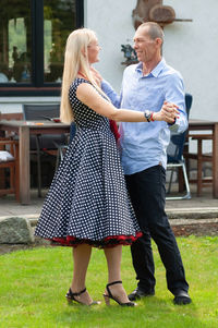 Beautiful young couple of newlyweds dancing tango on the lawn in the garden