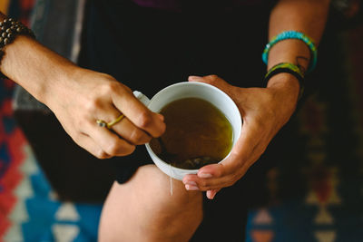 Midsection of woman holding coffee cup