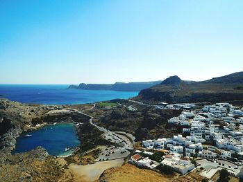 Scenic view of sea by town against clear blue sky