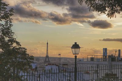 Street light and buildings against sky at sunset