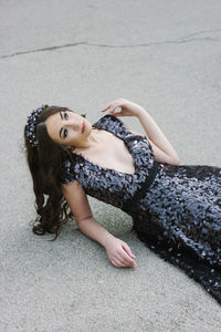 High angle view of young woman lying on footpath