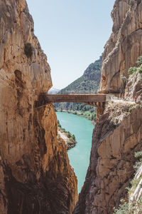 Bridge over mountain against sky