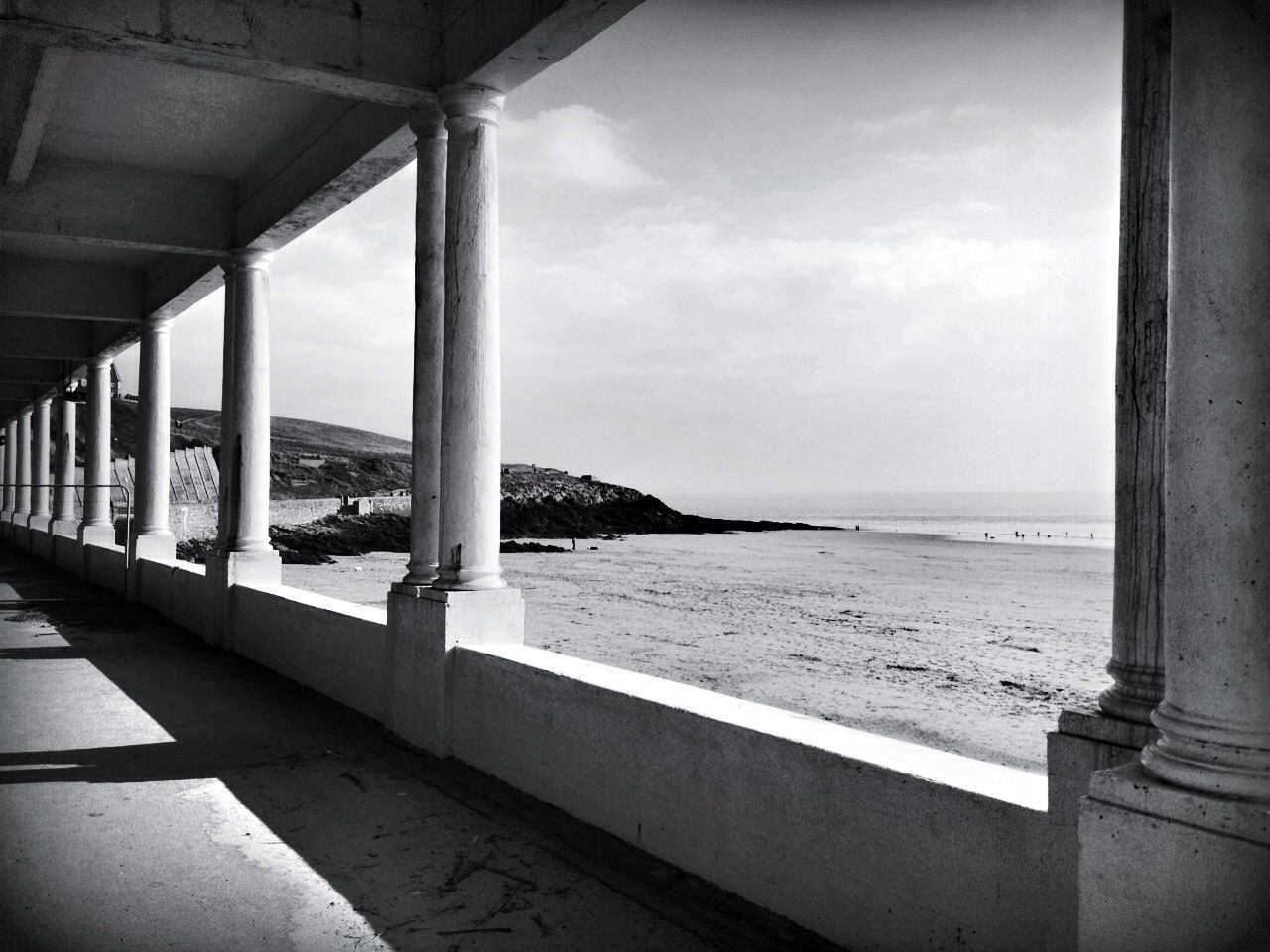 sea, horizon over water, water, sky, built structure, beach, architecture, architectural column, column, indoors, tranquility, cloud - sky, sand, tranquil scene, day, nature, shore, pier, railing, scenics