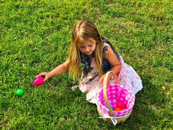 High angle view of girl playing with easter eggs at grassy field