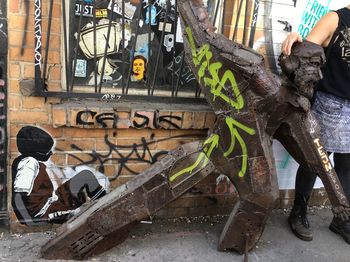 Low section of man standing by graffiti on city