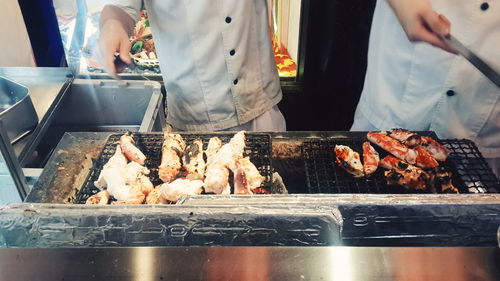 Low section of man standing on barbecue grill