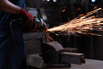 Midsection of young man welding metal in workshop