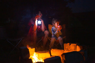 Rear view of woman sitting at night