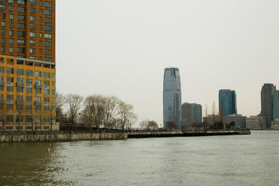 City by river against clear sky