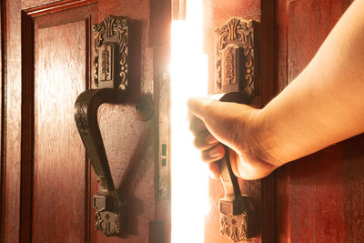 Close-up of hand holding door at home