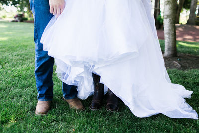 Low section of couple standing on grass