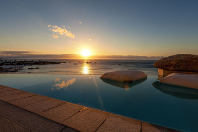 Landscaping view from the cliff located infinity pool to atlantic ocean at sunset time, capetown, sa