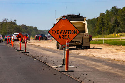 Information sign on road against sky