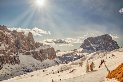 Wonderful sun over the snowy ski slopes in sella towers and grohmannspitze in the italian dolomites