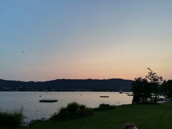 Scenic view of lake against clear sky during sunset