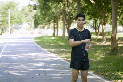 Portrait of a young man standing on road