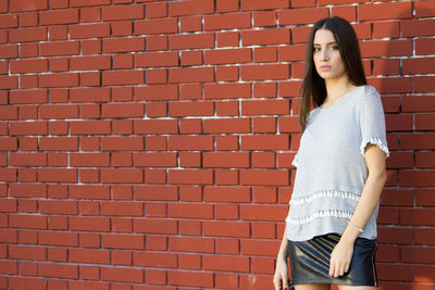 Woman standing against brick wall