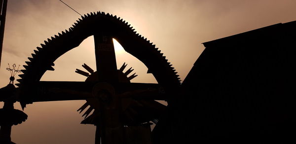 Low angle view of silhouette cross against sky during sunset