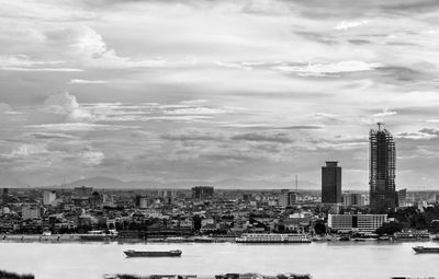 View of cityscape against cloudy sky