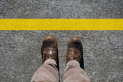 Low section of man standing on road